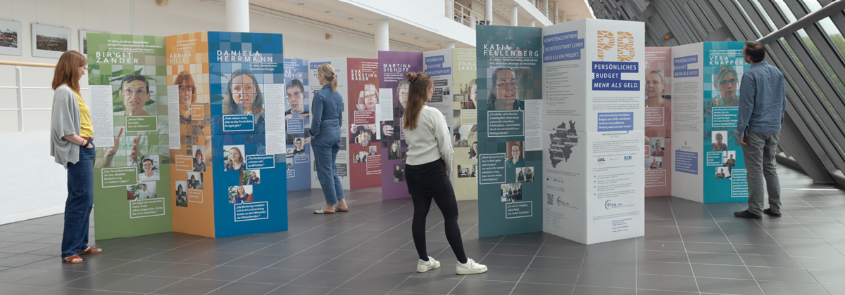 Personen betrachten die aufgebaute Wanderausstellung 